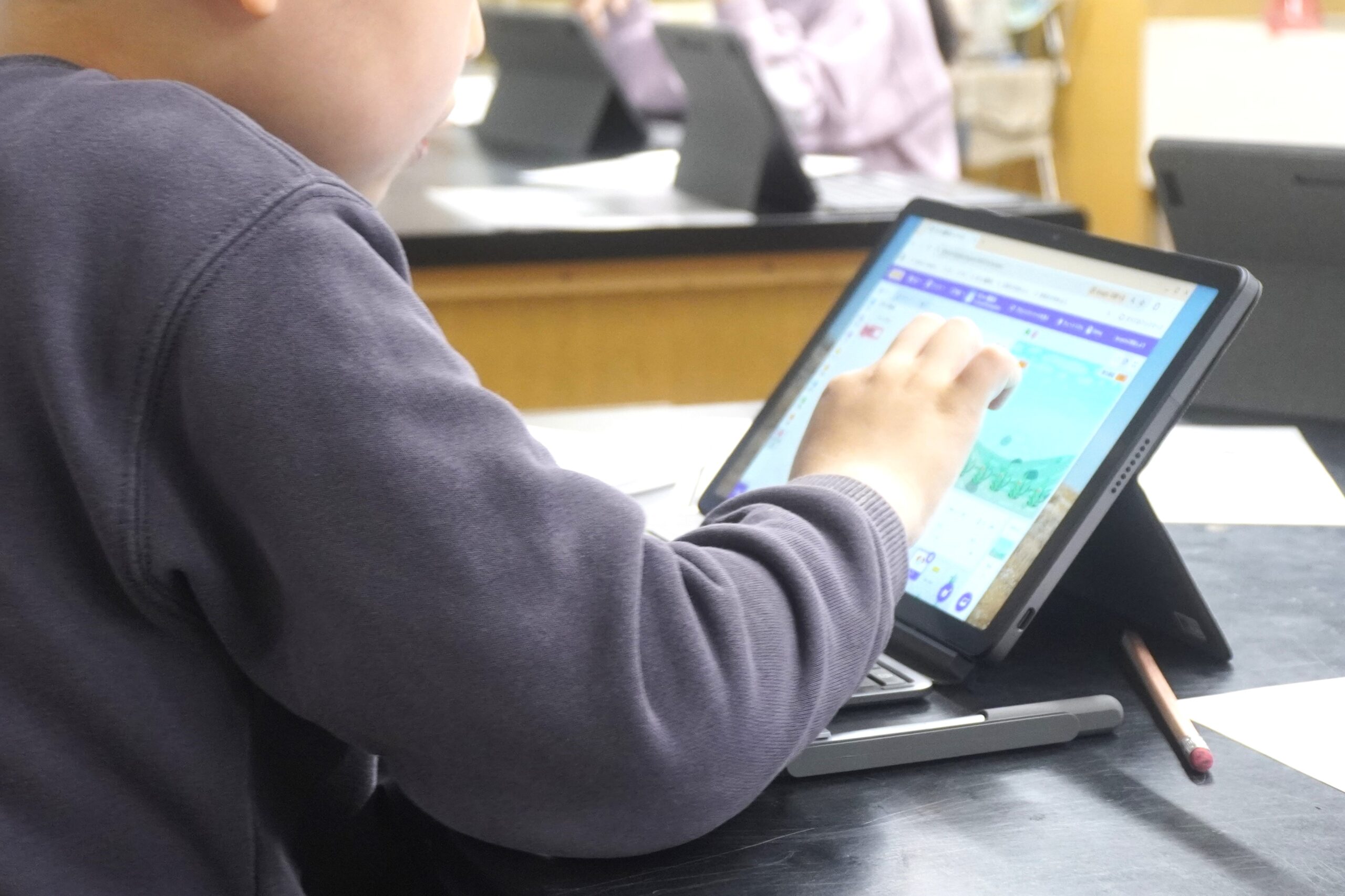 Scratchの画面と操作するこども