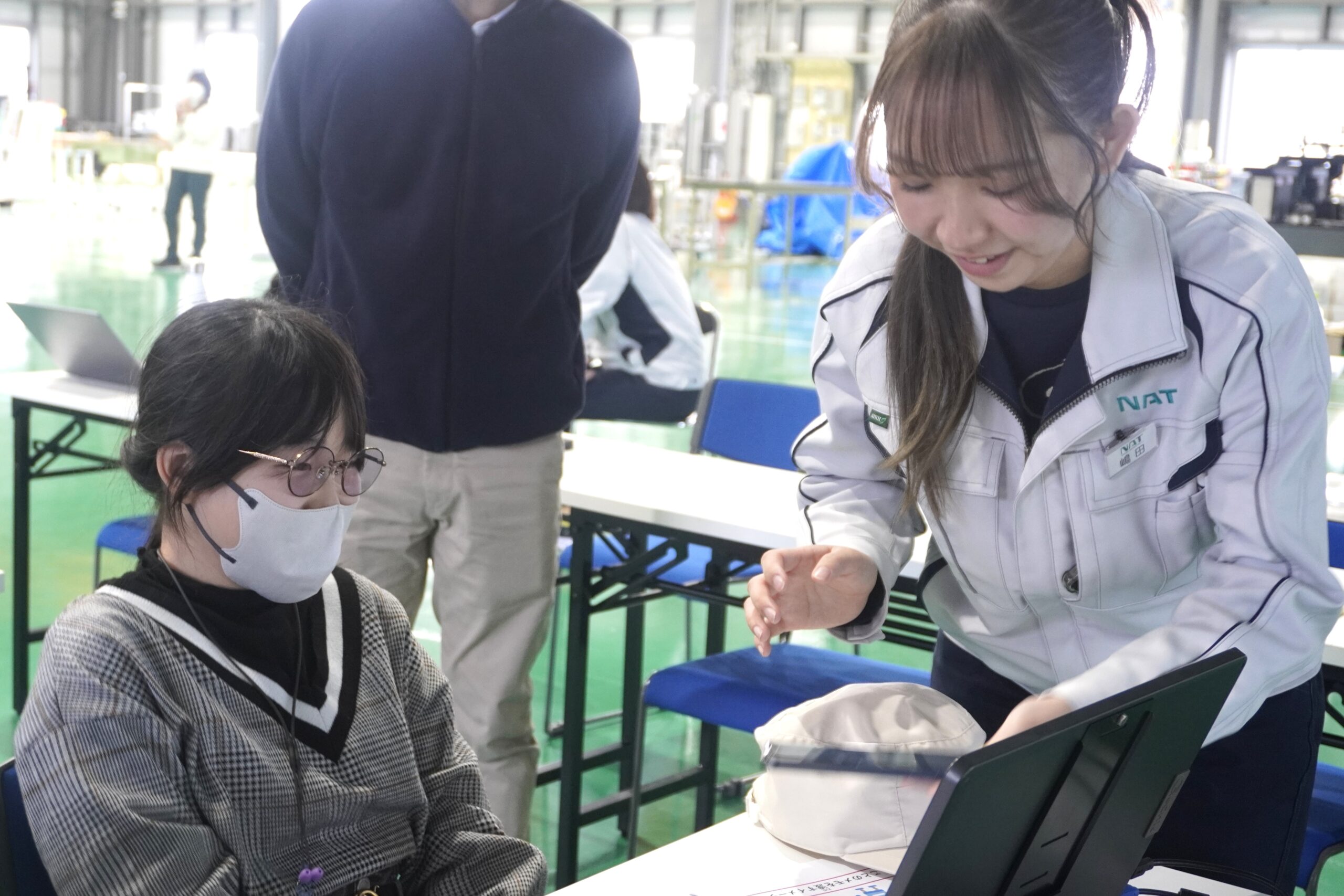 若手社員と子どもが席でやりとりをしている様子