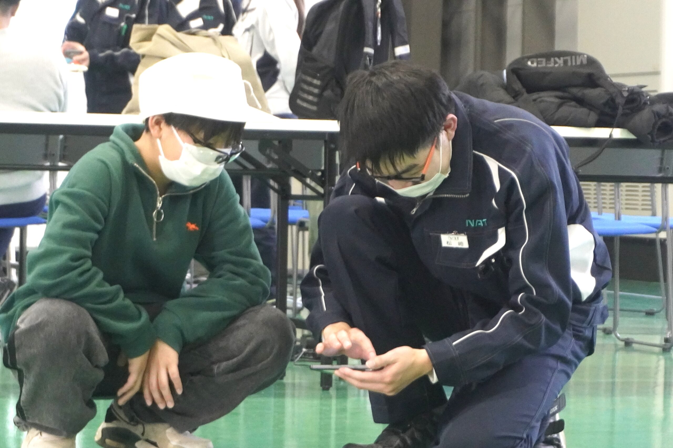 若手社員と子どもがスマートフォン端末を操作している様子